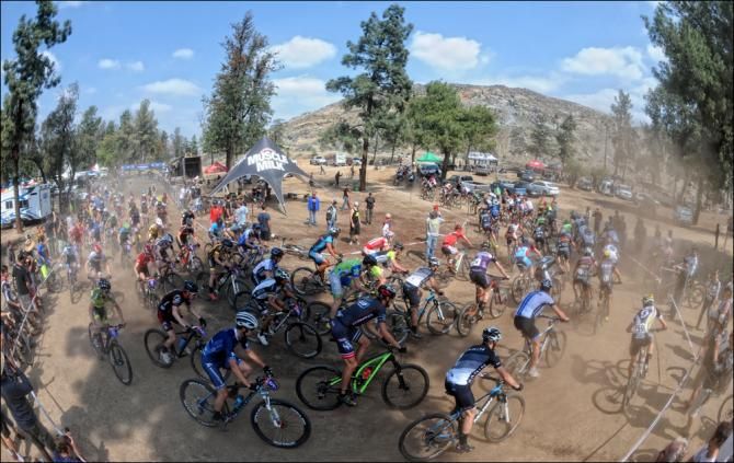 The elite men round the first bend after the start in Fontana in a cloud of dust.