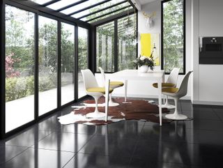 modern sunroom with dining table and black polished floor tiles, modern monochromatic scheme
