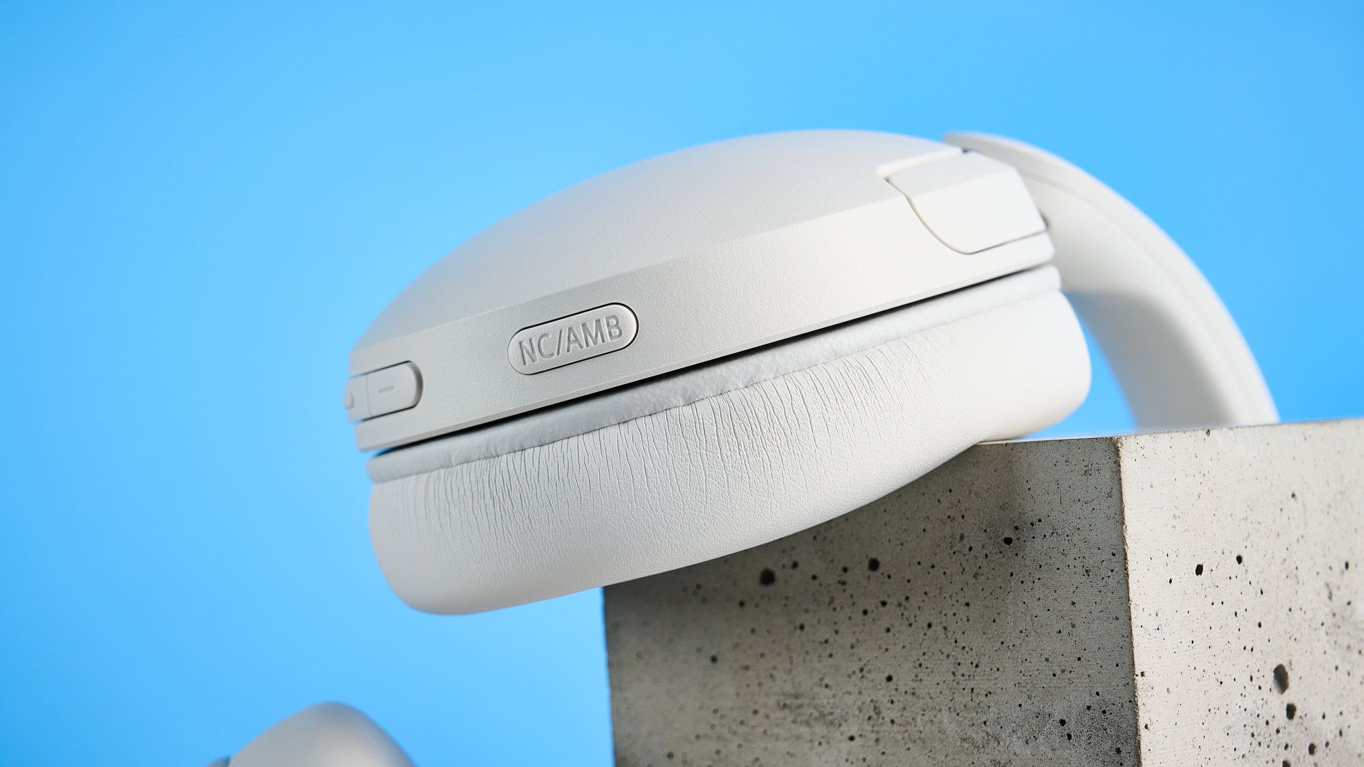 Sony WH-CH730N in white photographed in front of a blue background