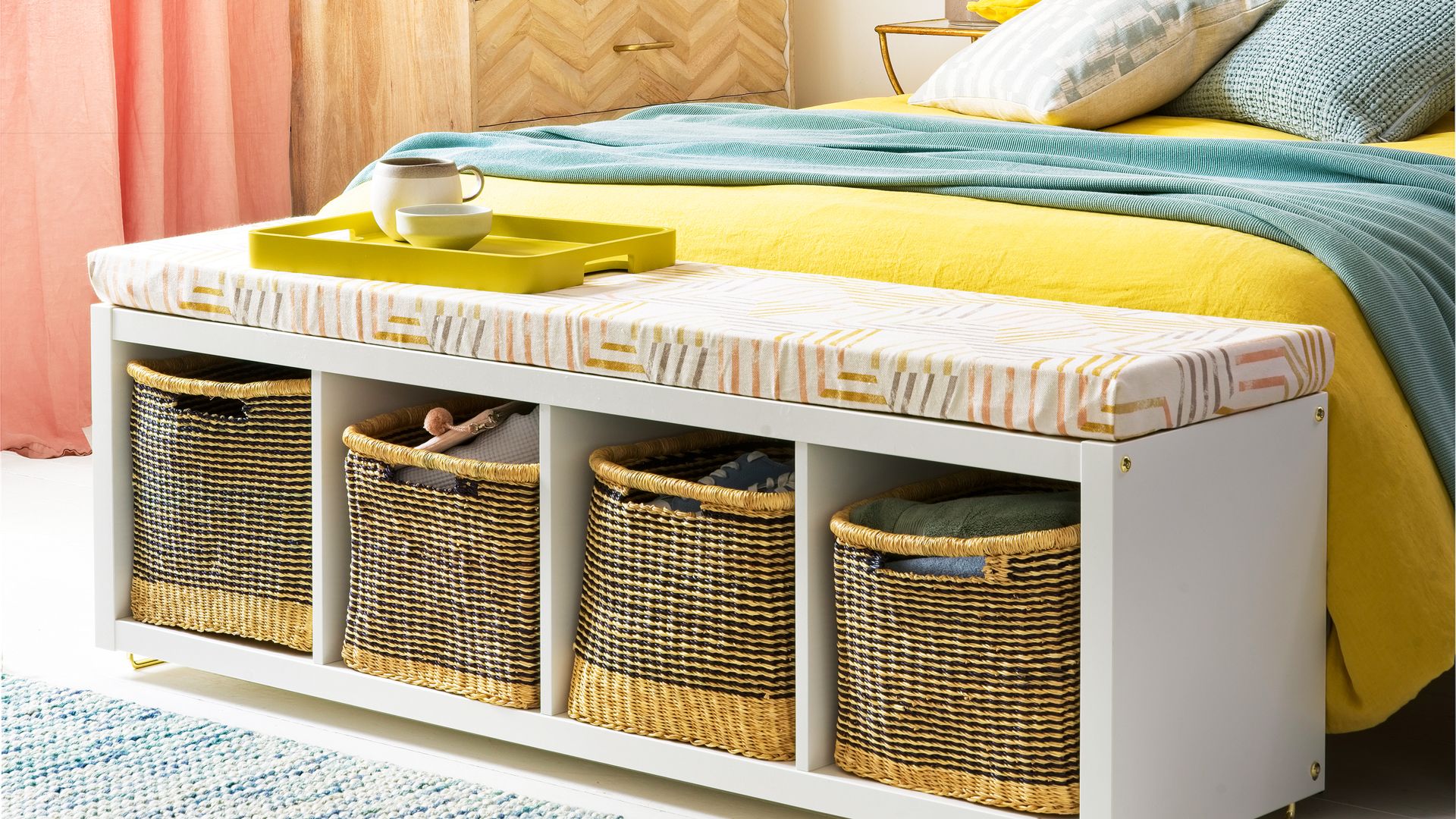 Bedroom with storage ottoman at the foot of the bed with woven baskets to keep the space tidy
