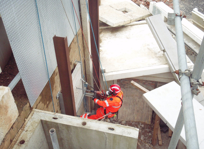 USAR Firefighter using breaking equipment while suspended.
