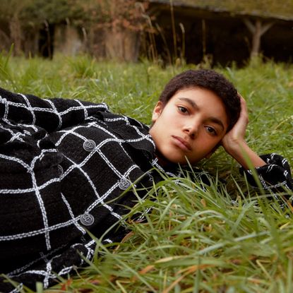 Girl in the grass wearing a boucle Chanel jacket