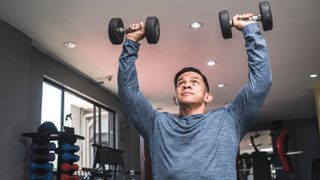 Man performing dumbbell shoulder press