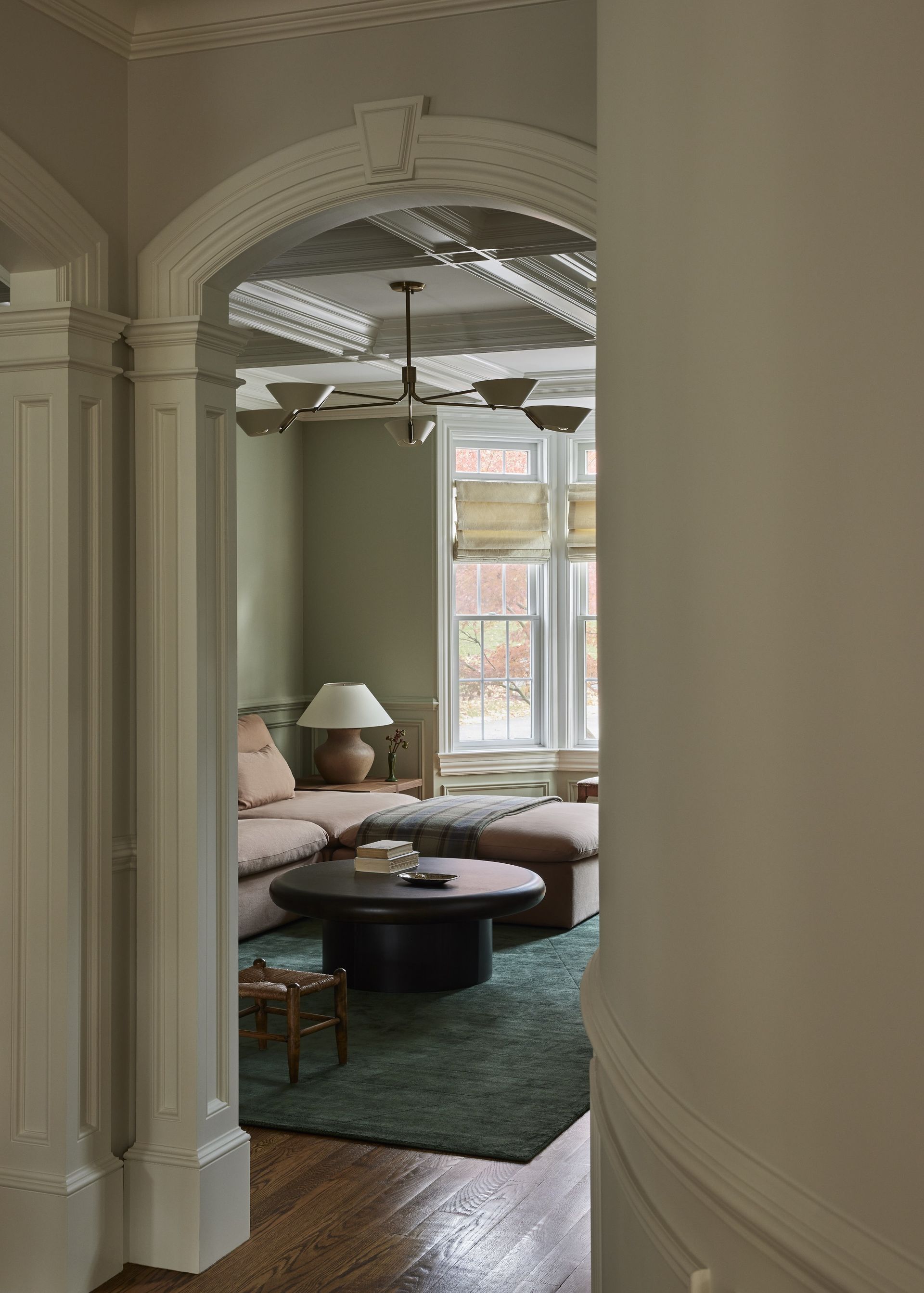 A hallway that leads through to a green living room