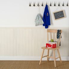 room with white wall and wooden peg rail and chair