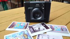 A black and gray Fujifilm Instax Wide Evo hybrid instant camera