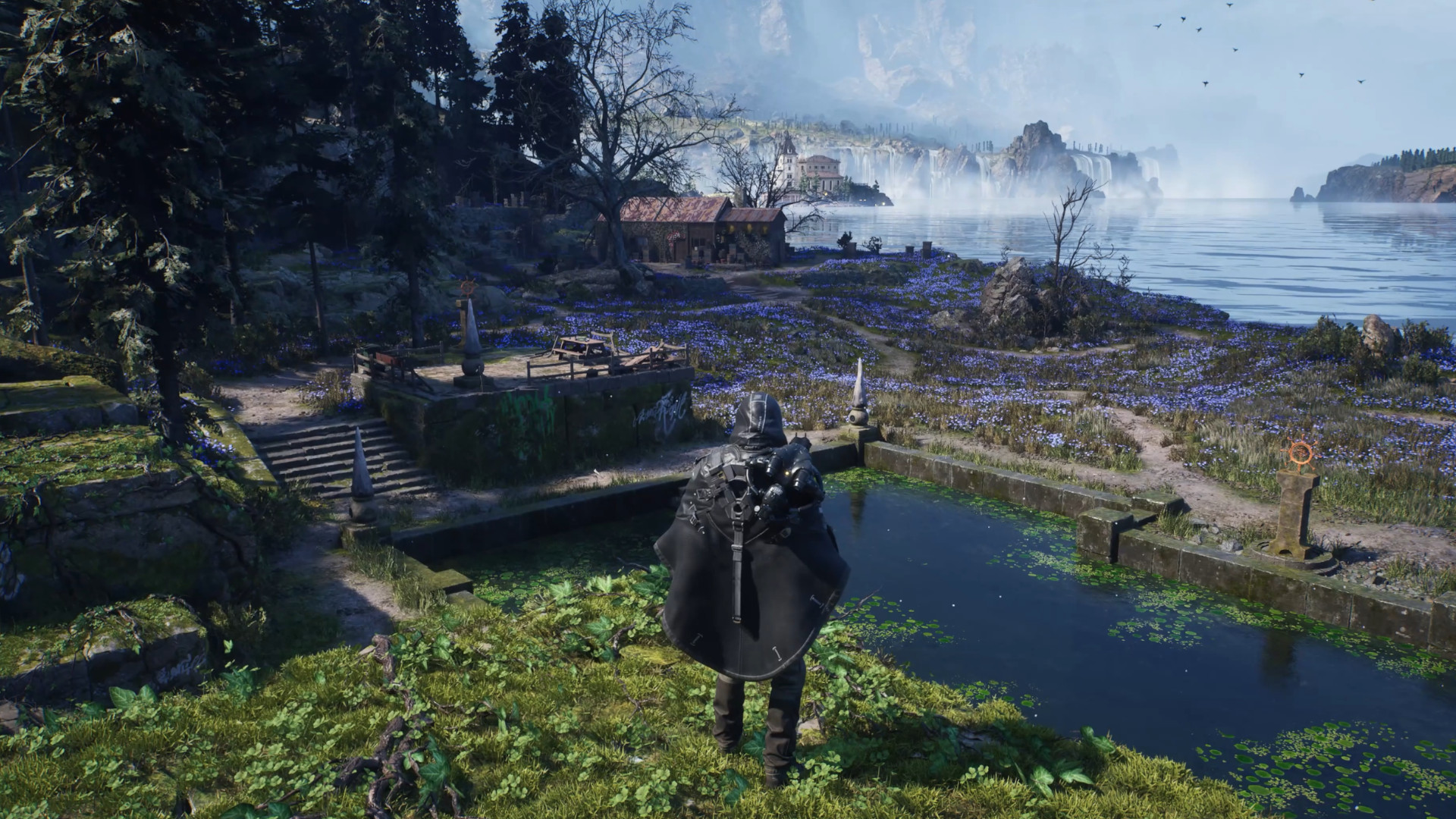 Remi stands above a manmade pond in Hell is Us, looking out across a surprisingly pretty area in Hadea full of blooming flowers