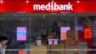 People walk past a shop front for Australia's largest health insurance company Medibank, in Sydney on November 11, 2022.