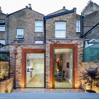 a contemporary glass extension added to terraced victorian house by IQ glass solutions, with a white kitchen extension inside with wooden floor