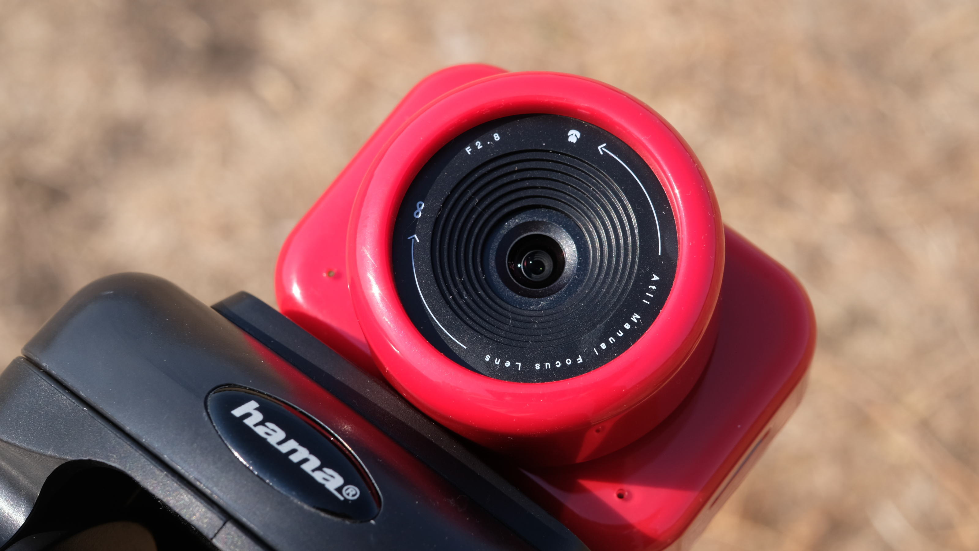 Photograph of the ATLi Eon time-lapse camera in red, mounted on tripod