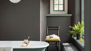 grey and green bathroom with green rolltop bath and small window