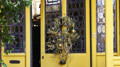 Bright and cheery front door color ideas a yellow door with christmas wreath