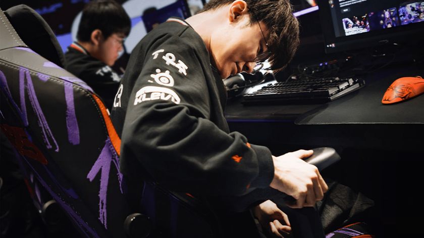 An esports gamer adjusts his armrest while sat a desk