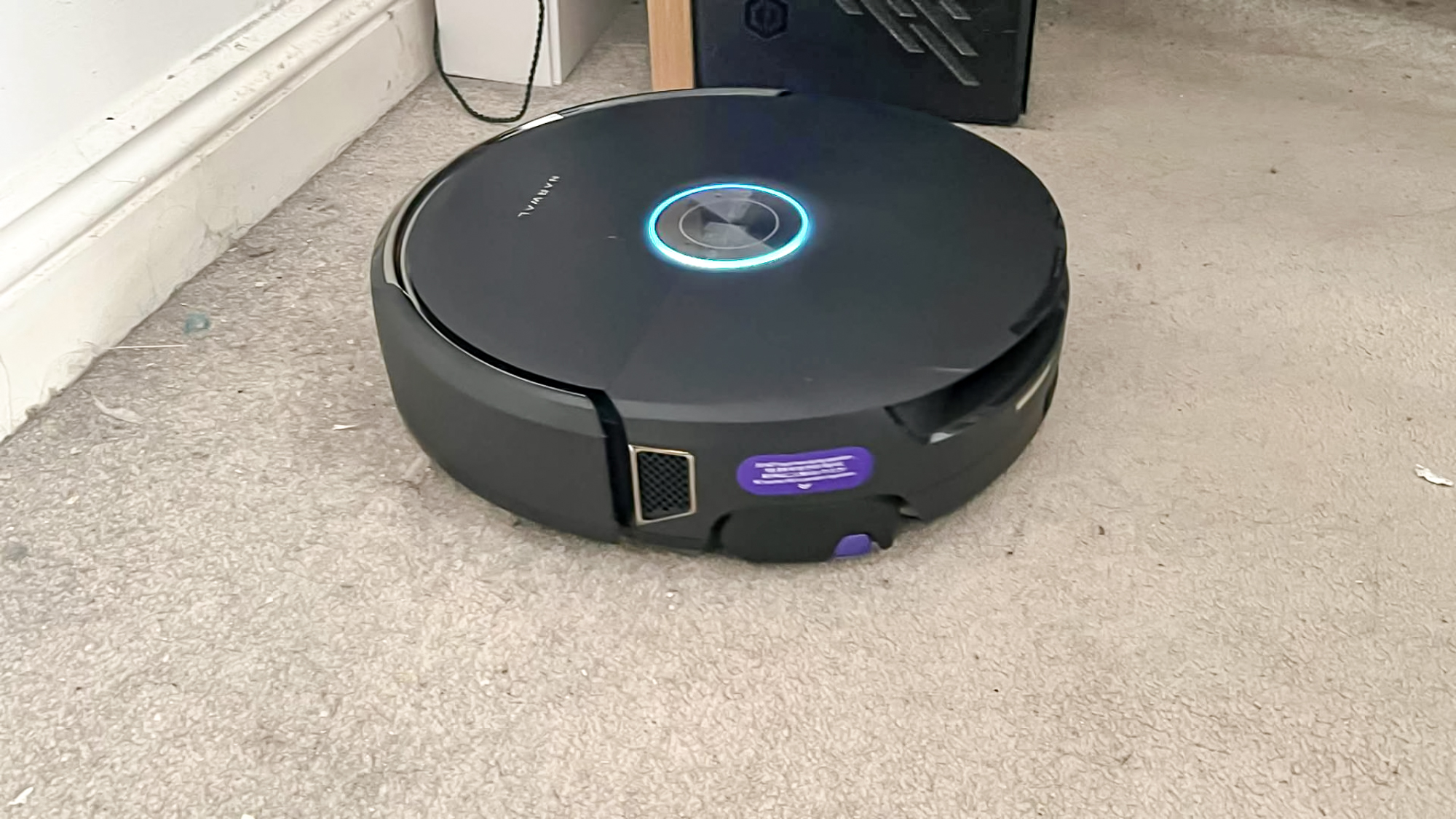 Black Narwhal Flow robot vacuum on a carpet