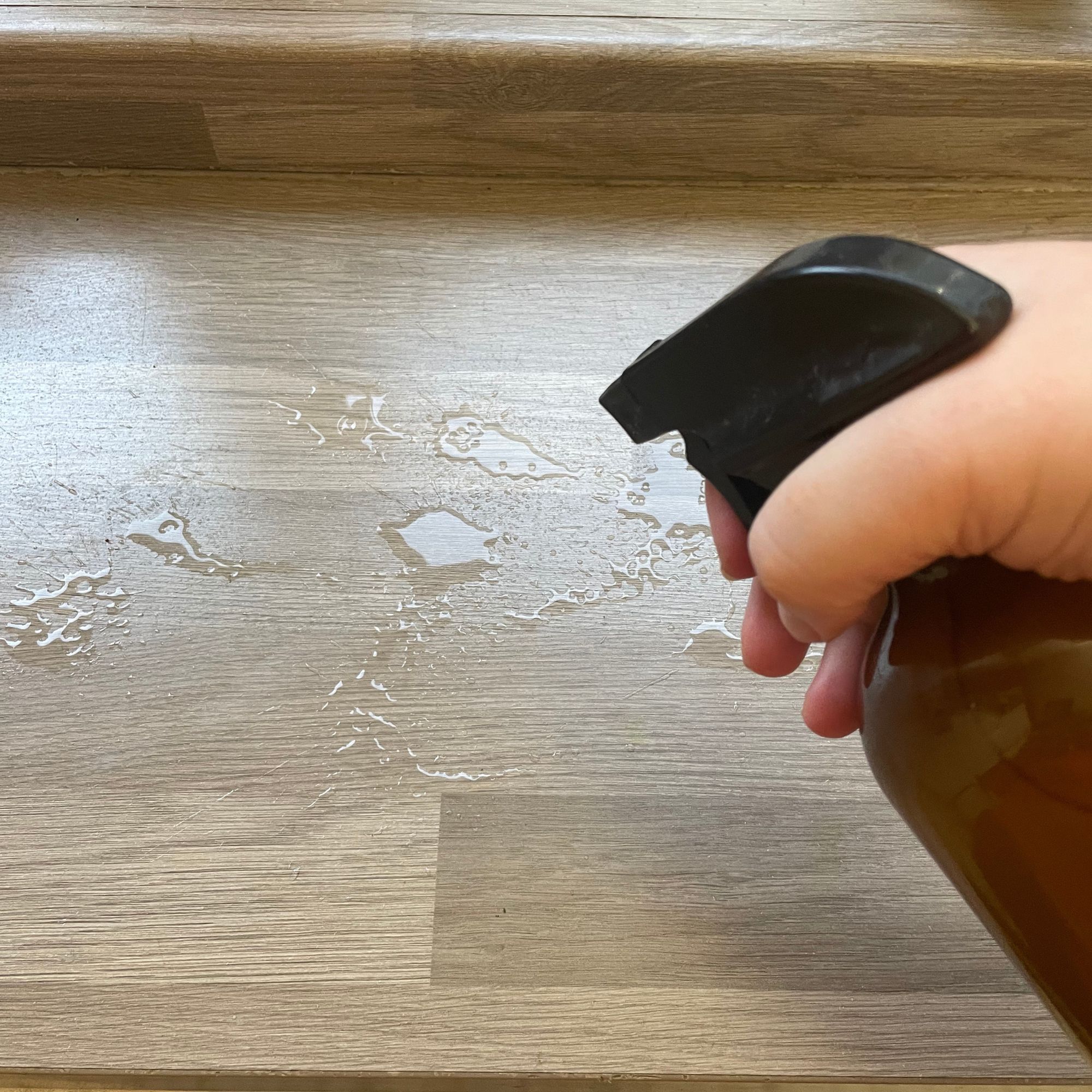 Spraying rice water on wood-effect kitchen worktop