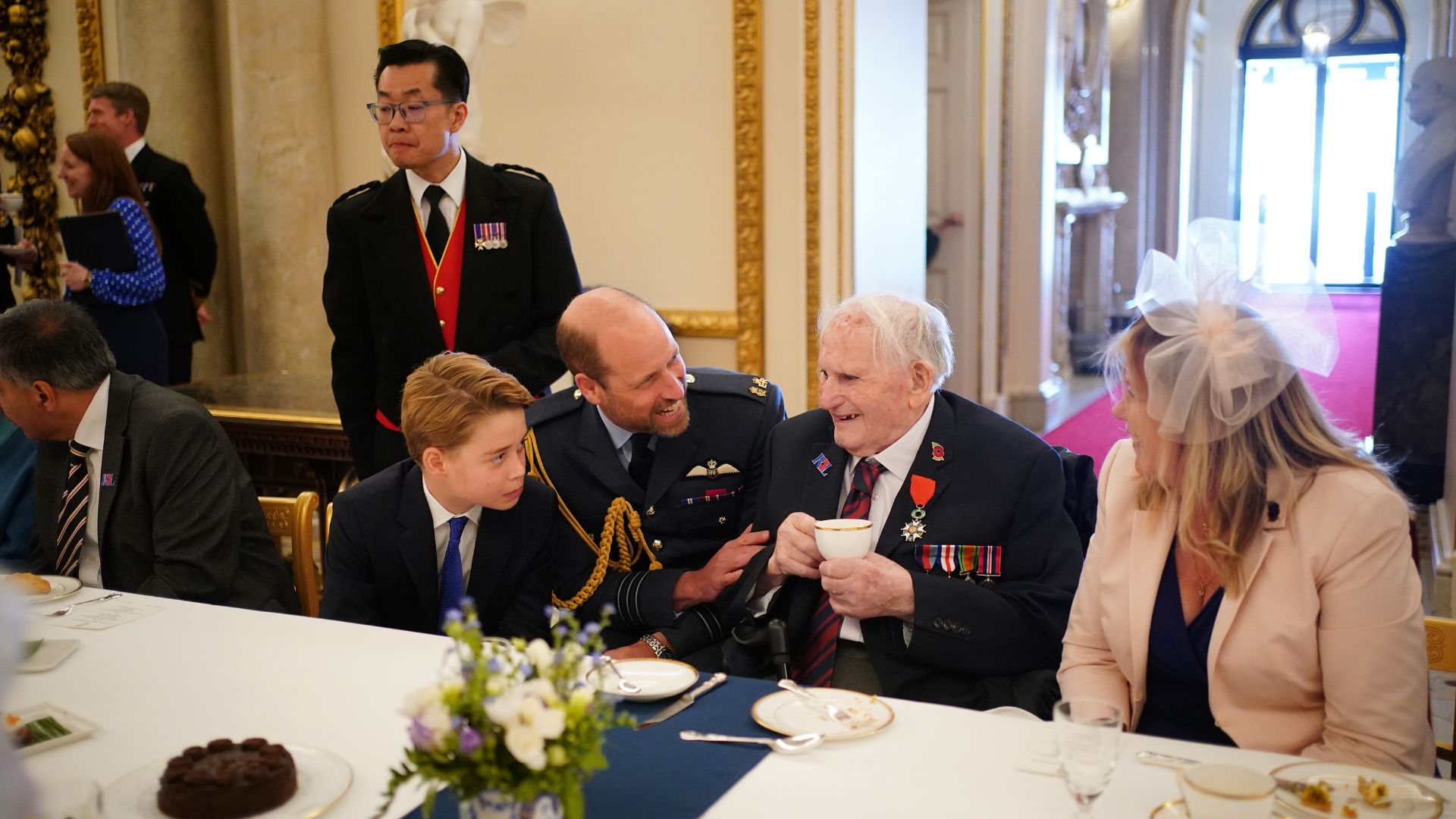 Prince George of Wales and Prince William speak with Second World War veterans at a tea party in Buckingham Palace on May 5, 2025