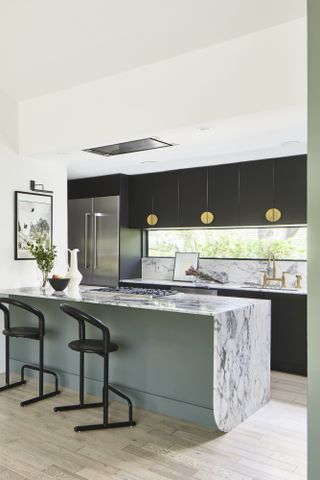 Black accents in a sage green kitchen