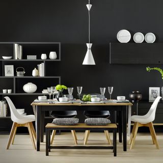 All-black dining room with black painted table and white dining chairs and accents