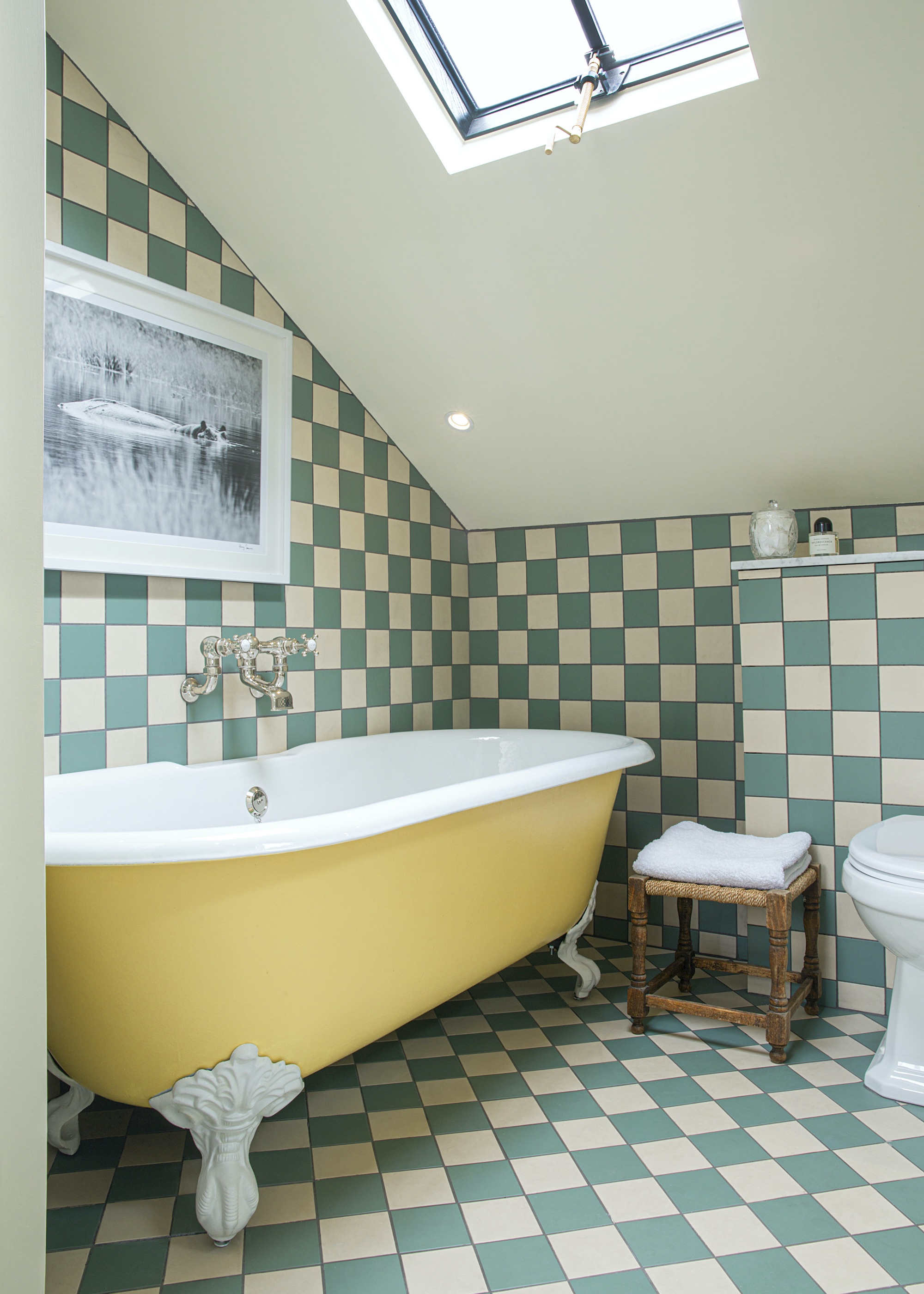 loft bathroom with checkered tiling and yellow bath