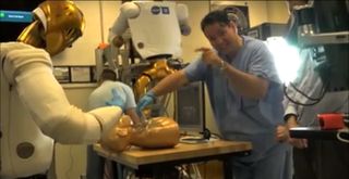 NASA's Robonaut 2 and Dr. Zsolt Garami, of the Houston Methodist Research Institute, practice telemedicine techniques during a test of the robot's bedside manner. This image is a still from a NASA video documenting the Robonaut 2 test.