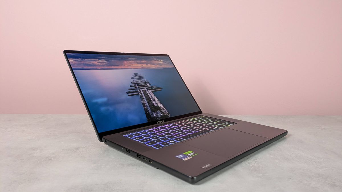 Three-quarter view of MSI Stealth 16 AI+ open on a white desk with pink wall in background