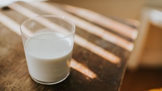 Milk in glass sitting on wooden table