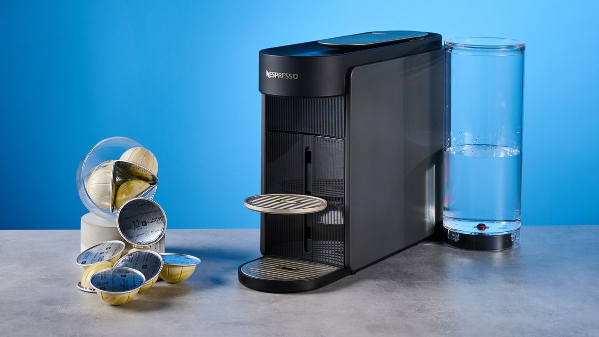 the nespresso vertuo up machine photographed against a blue background