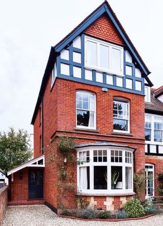 a porch extension on a traditional Victorian house with a gravel driveway