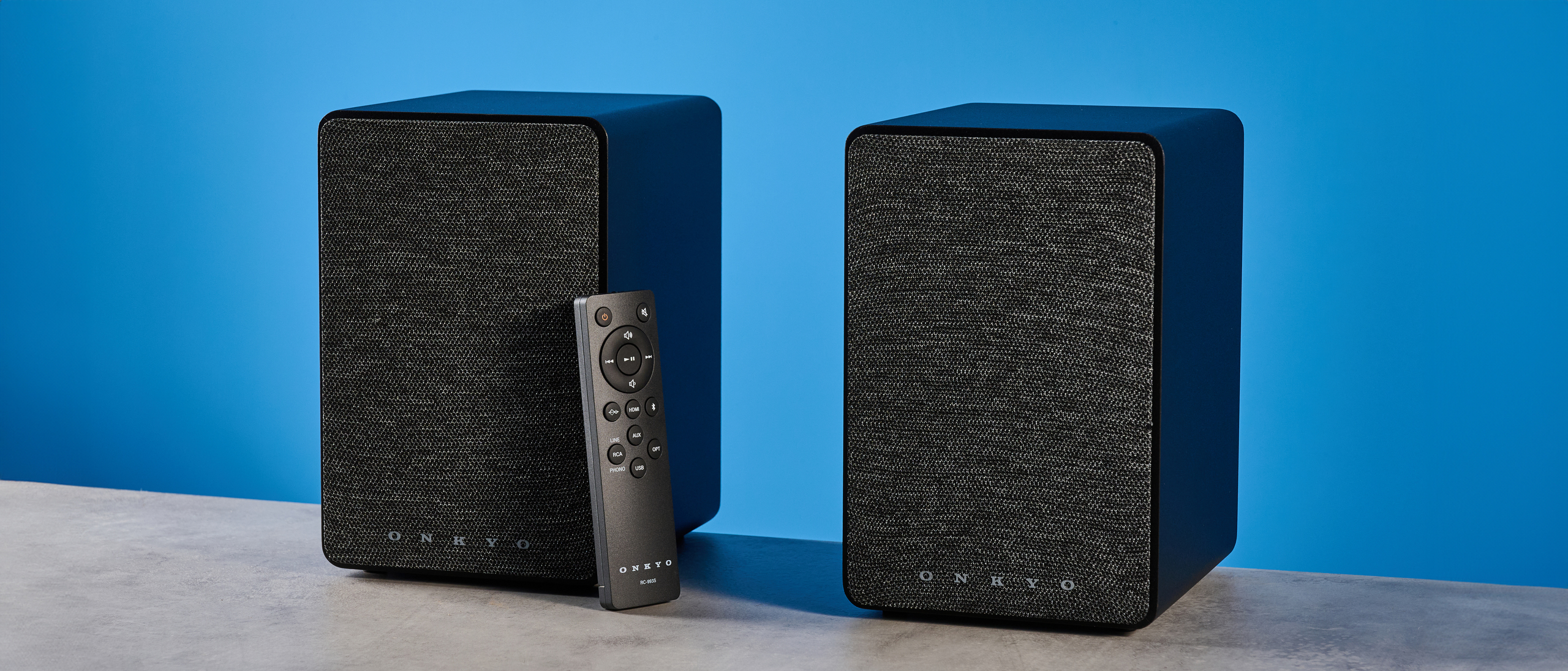 Onkyo GX-30ARC bookshelf speakers photographed on a blue background