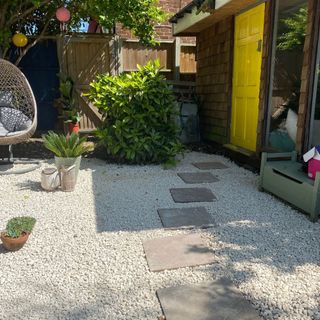 garden makeover with yellow door paving stone and potted plant
