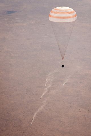 Ground support vehicles can be seen chasing the Soyuz TMA-21 spacecraft as it lands with Expedition 28 Commander Andrey Borisenko, and Flight Engineers Ron Garan, and Alexander Samokutyaev in a remote area outside of the town of Zhezkazgan, Kazakhstan, on