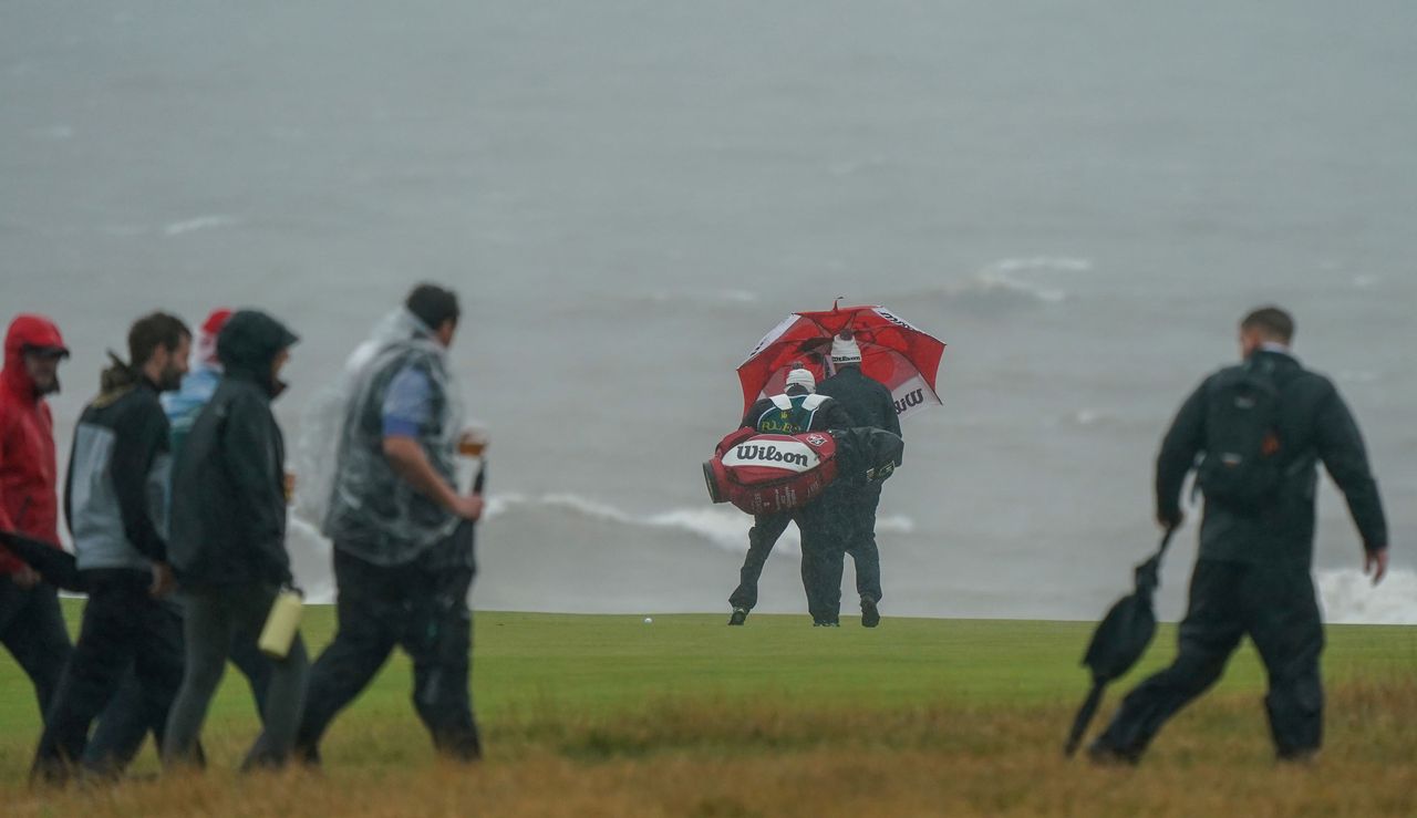 Harrington and his caddie under an umbrella