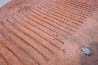 closeup of tire tracks on red sand.
