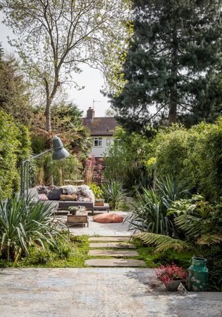 modern garden ideas with seating area that leads through to wilder garden