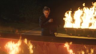 Frances McDormand looking at a burning billboard