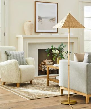 Rattan floor lamp in neutral living room with boucle armchair and fireplace