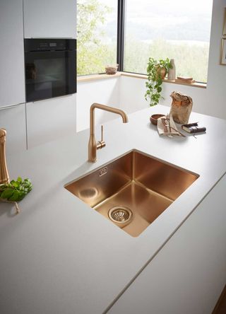 modern white kitchen island with brass undermounted kitchen sink and brass kitchen tap