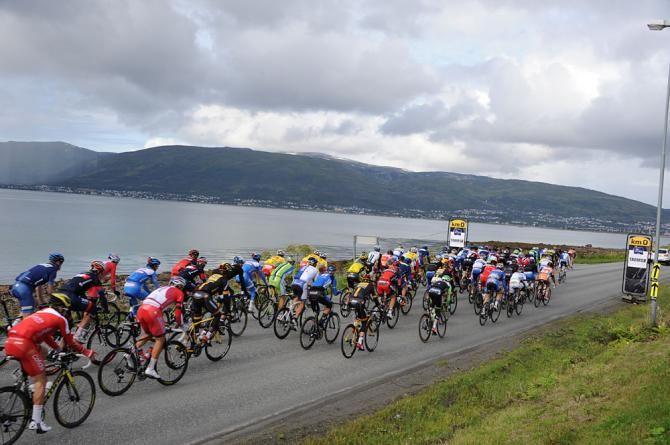 The peloton hugs the shoreline