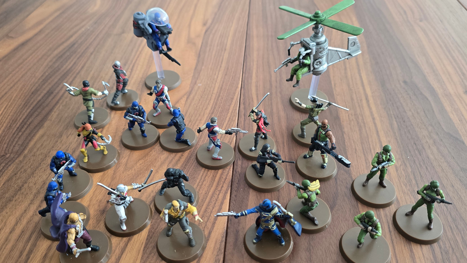 A selection of Heroscape models from the G.I. JOE range face off on a wooden table