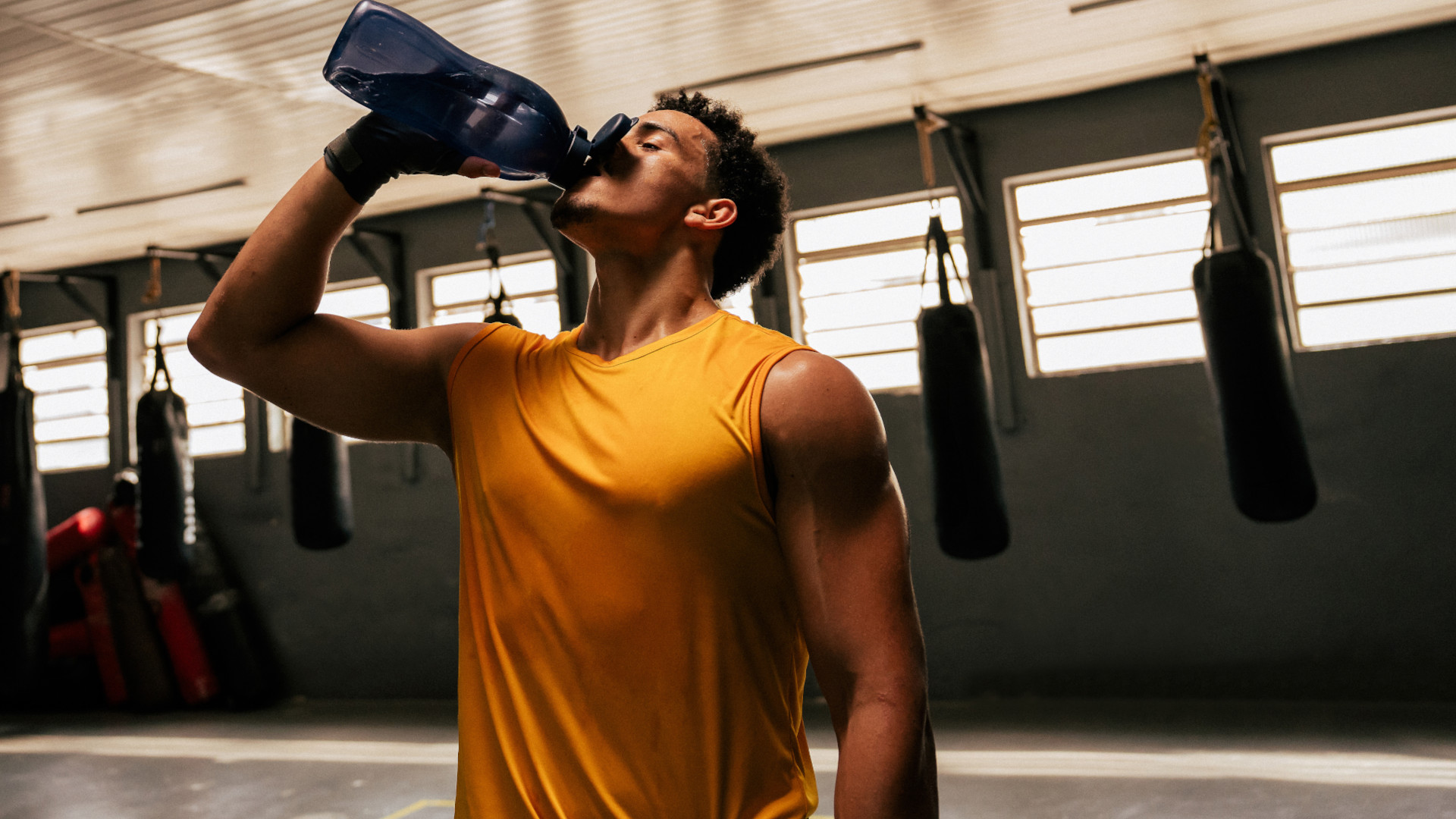 A man drinking protein powder at the gym
