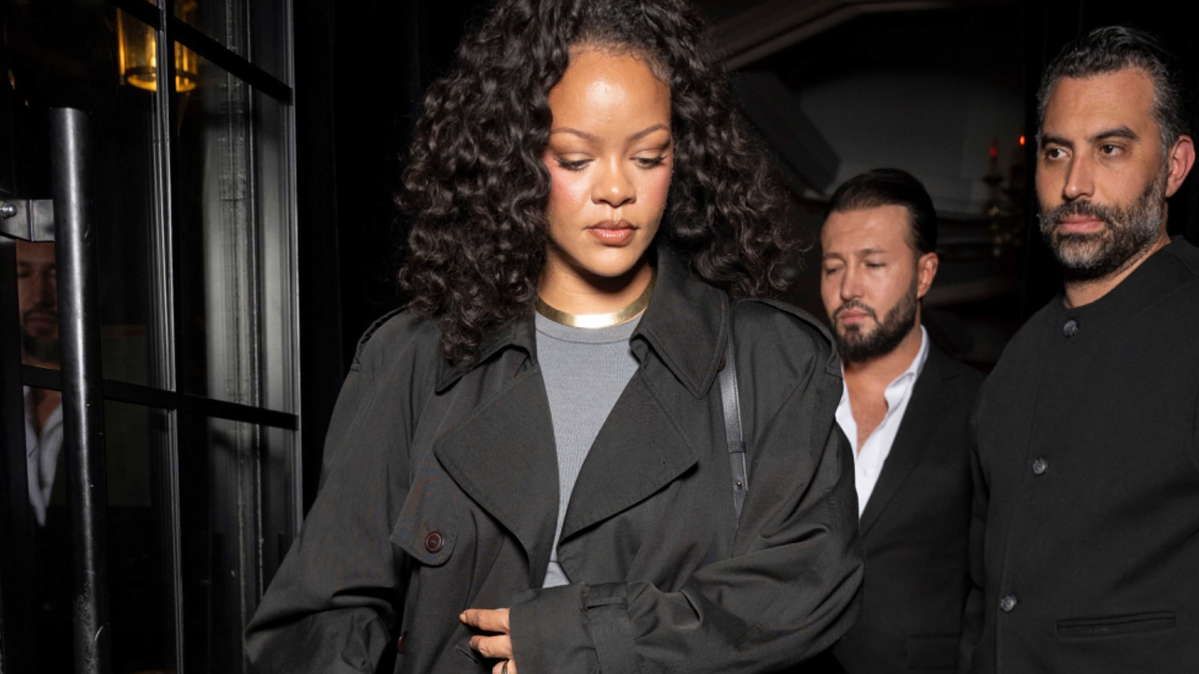 rihanna wears a black trench coat with a gray t-shirt.