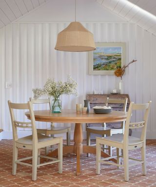 modern farmhouse dining room with white shiplap walls and terracotta floors