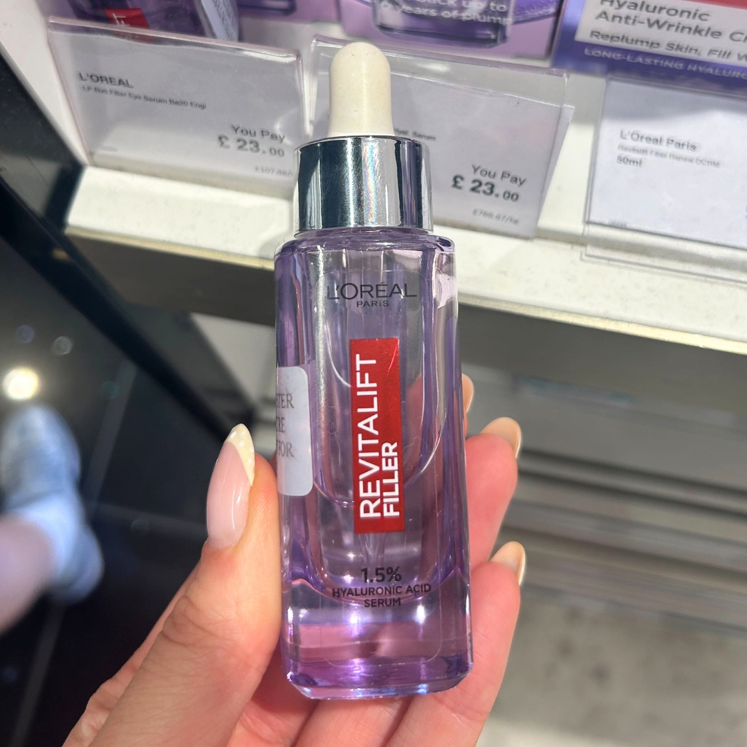 Hand holding bottle of L'Oreal Revitalift Hyaluronic Acid Serum in World Duty Free