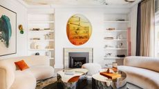 Living room of this San Francisco house with cream curved sofas and multicolor accents