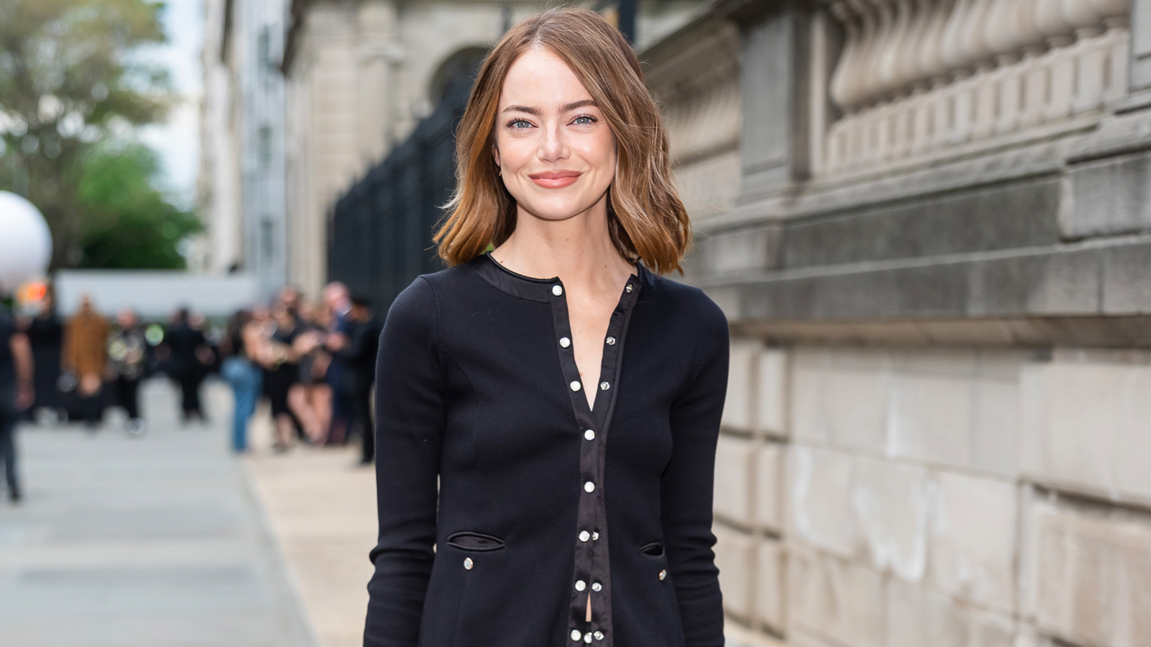 Emma Stone wears a lightweight black buttoned jacket.