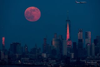 As the Strawberry Minimoon rises over New York City, a British Airways plane descends toward Newark Liberty International Airport in this photo taken by Stan Honda on June 9.