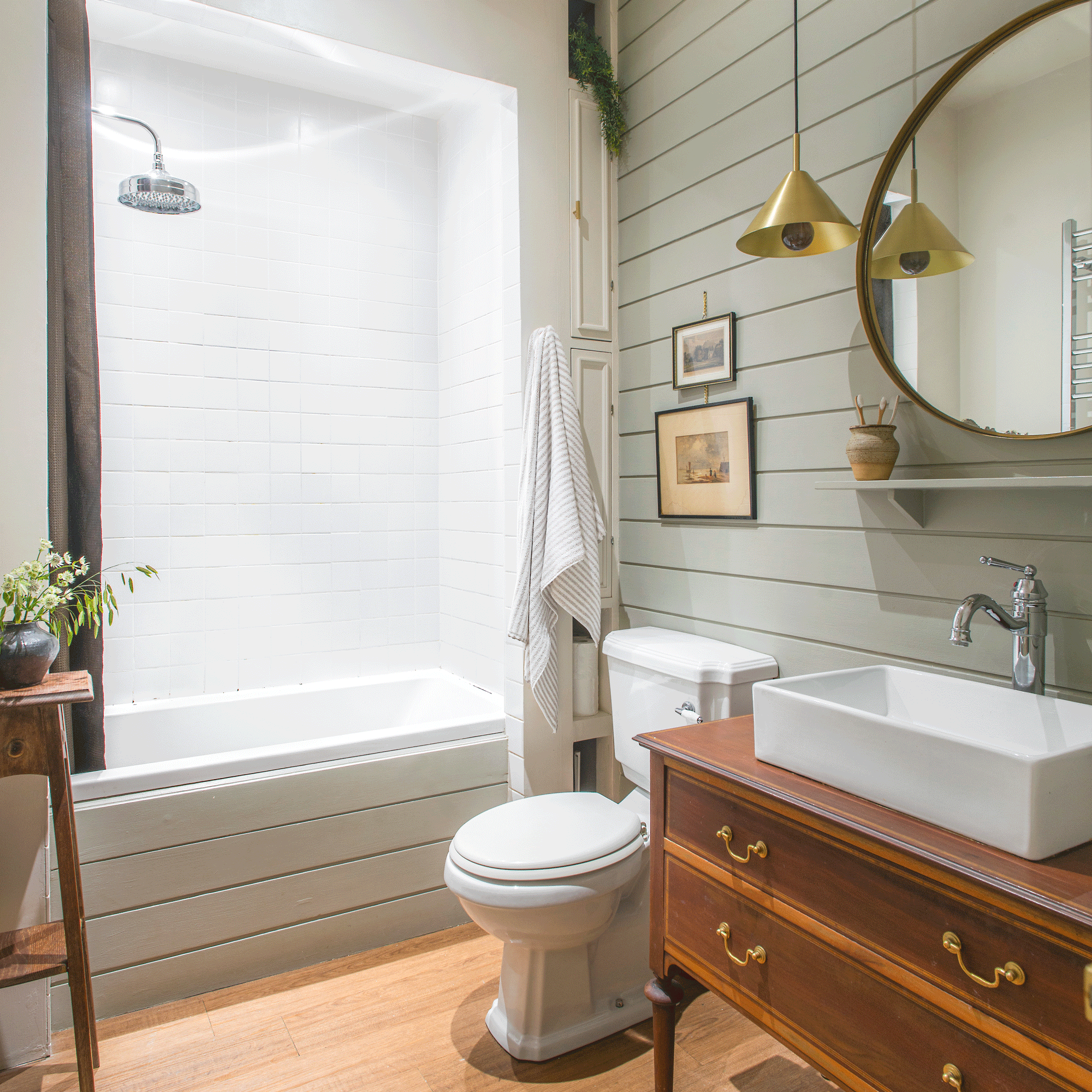 a wood panelled bathroom with bath, shower and vintage vanity unit