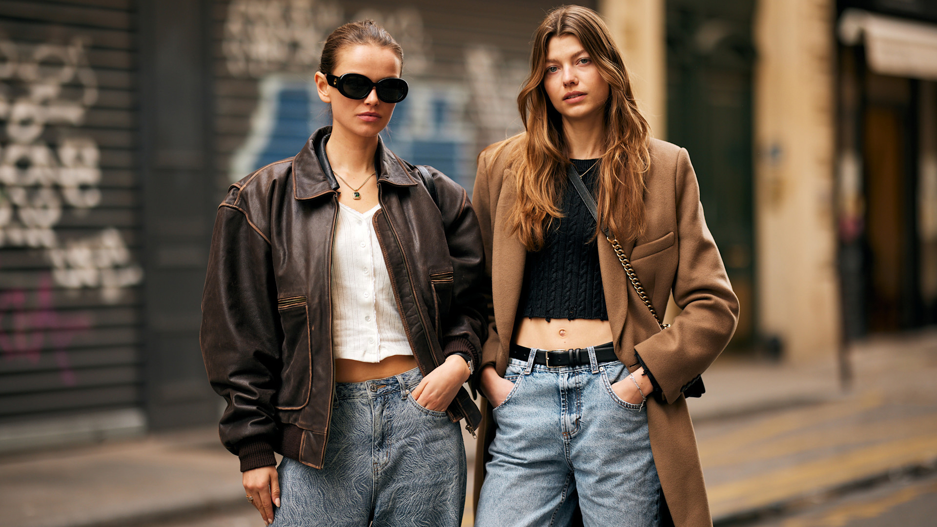 two fashion week attendees wear brown coats and jackets with denim