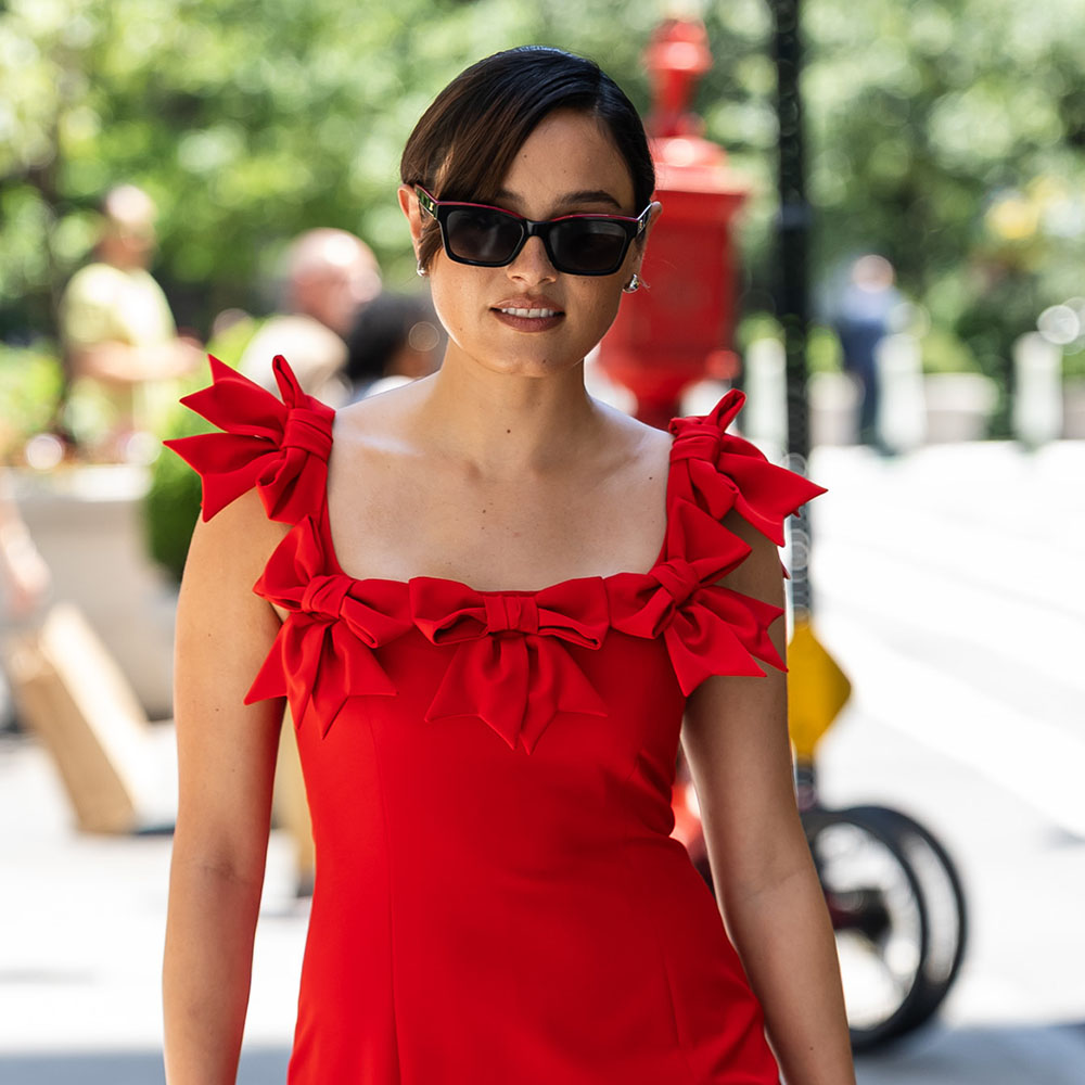 Chase Sui wearing a red bow dress and sunglasses in NYC