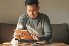 Man sitting at home using tablet